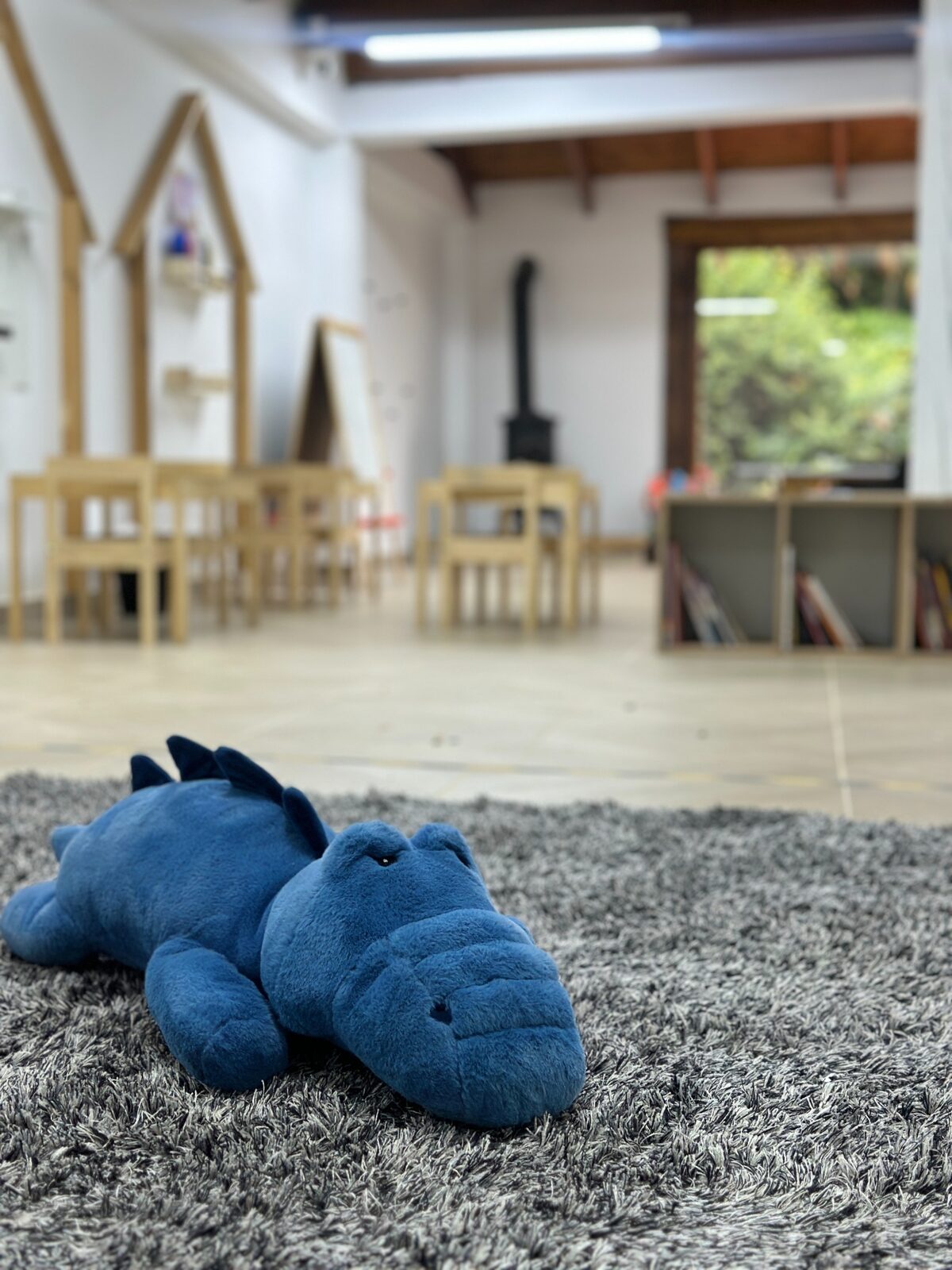 Cocodrilo de peluche azul en el espacio de juego de preescolar de Hom Sabana